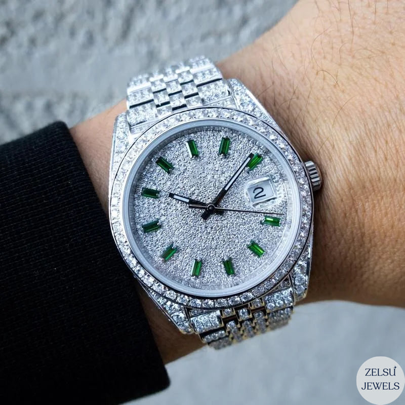 Luxury silver diamond watch featuring a green emerald diamond dial and sparkling diamonds.