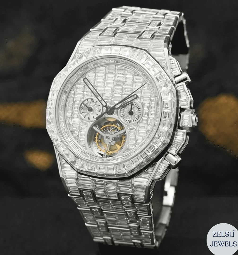 Silver watch with emerald bezel and diamond bust-down design, offering a combination of luxury and vibrant color.
