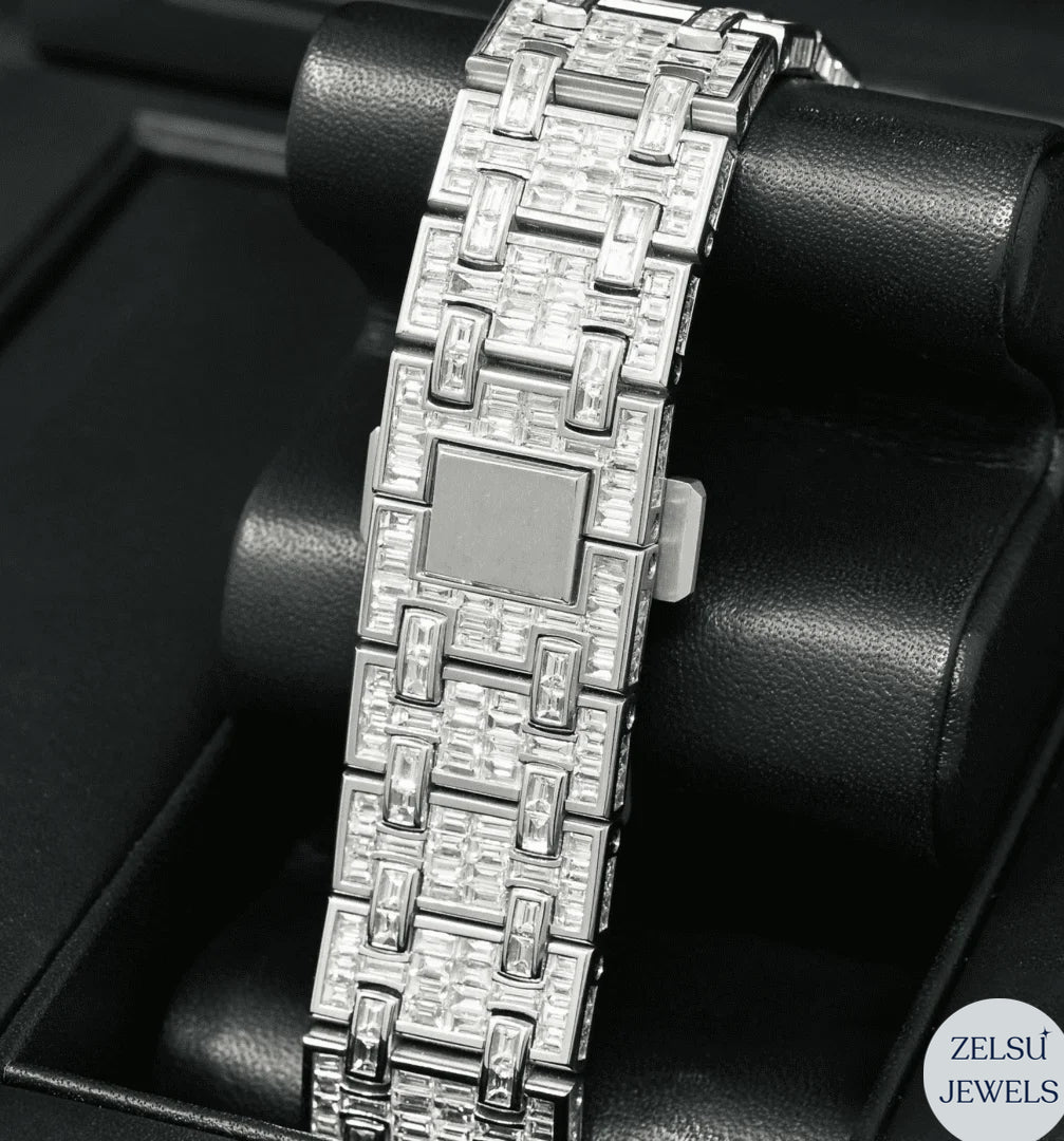 Luxury silver watch with emerald bezel and bust-down design, featuring radiant diamonds for a striking appearance.