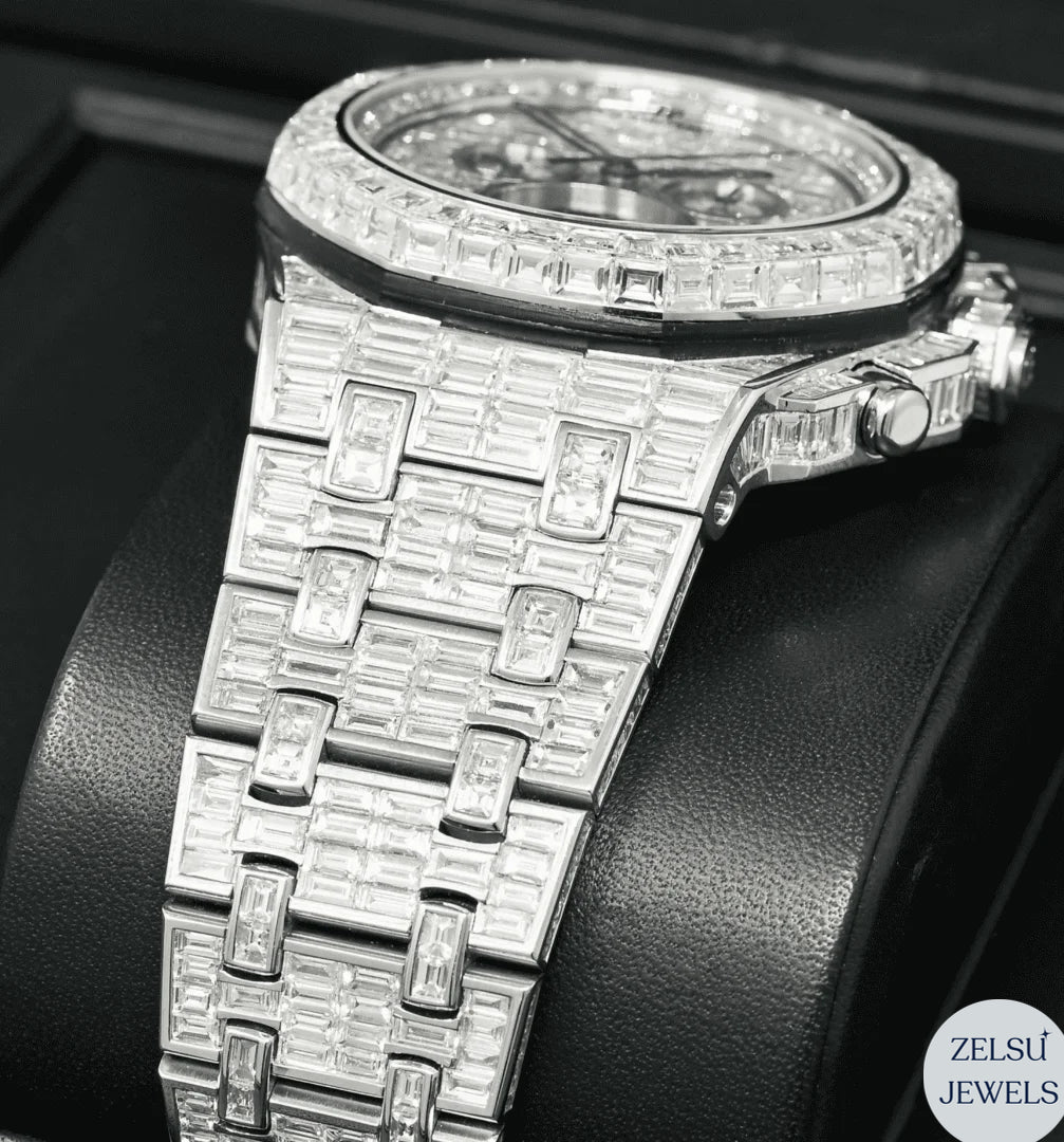 Luxury silver watch with emerald bezel and full bust-down design, featuring radiant diamonds and stunning craftsmanship.