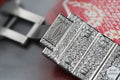 Sophisticated bust-down diamond watch with radiant blue diamonds in the crown bezel, offering a high-end appeal.