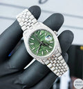 Luxury Rolex-inspired silver diamond watch featuring a rich green dial and sparkling diamonds.
